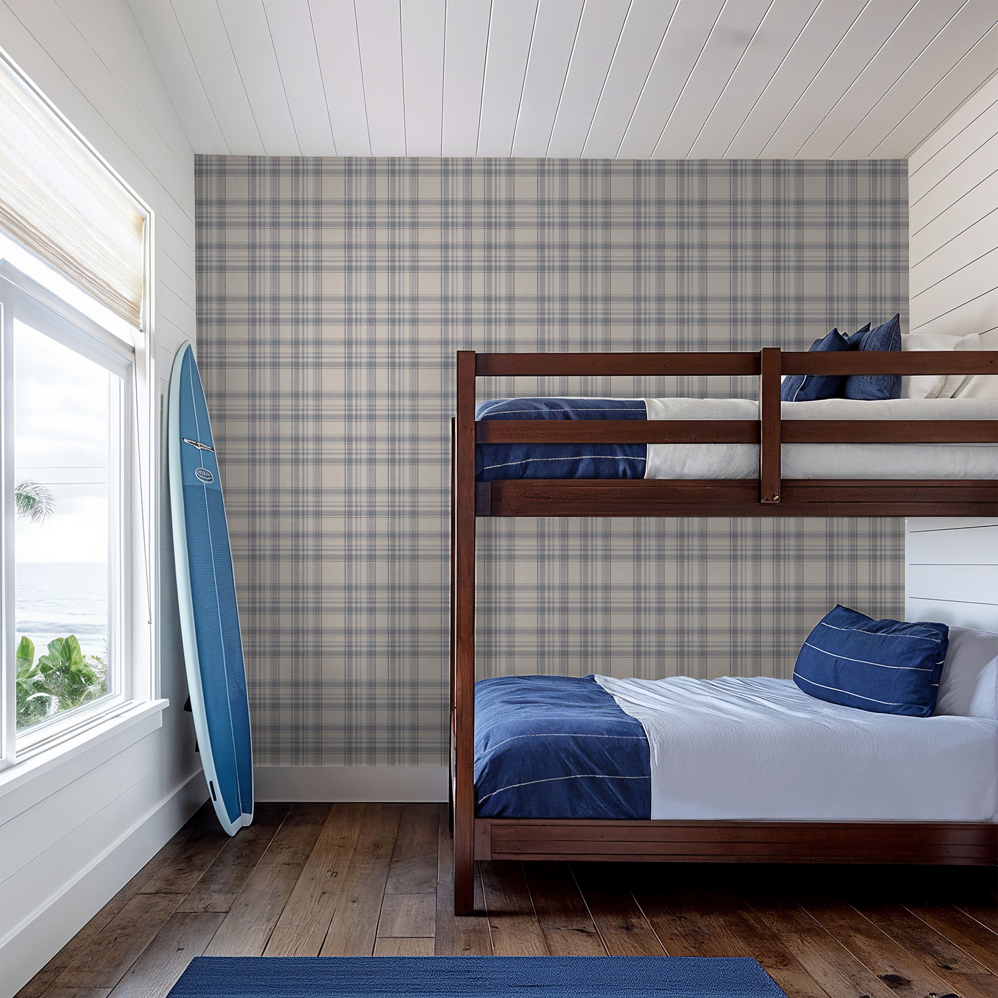Bunk bed in a room with Tweed Plaid - Navy Blues wallpaper and a surfboard leaning against the wall.