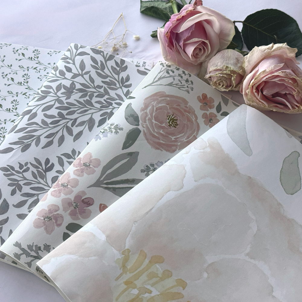 Personalized floral nursery wallpaper featuring soft blush pink roses, delicate greenery, and watercolor botanical patterns in muted sage and ivory tones, styled for a baby girl’s nursery or romantic kids’ room décor — artist-drawn design perfect for custom nursery wall décor and elegant children’s room styling.