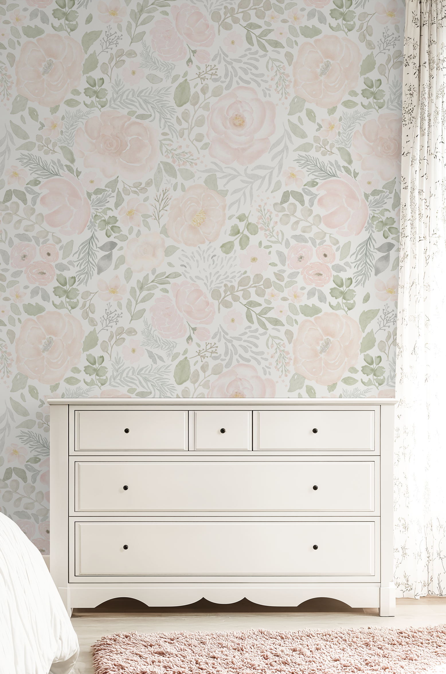 White dresser against a floral wallpapered wall with a pink rug on the floor.