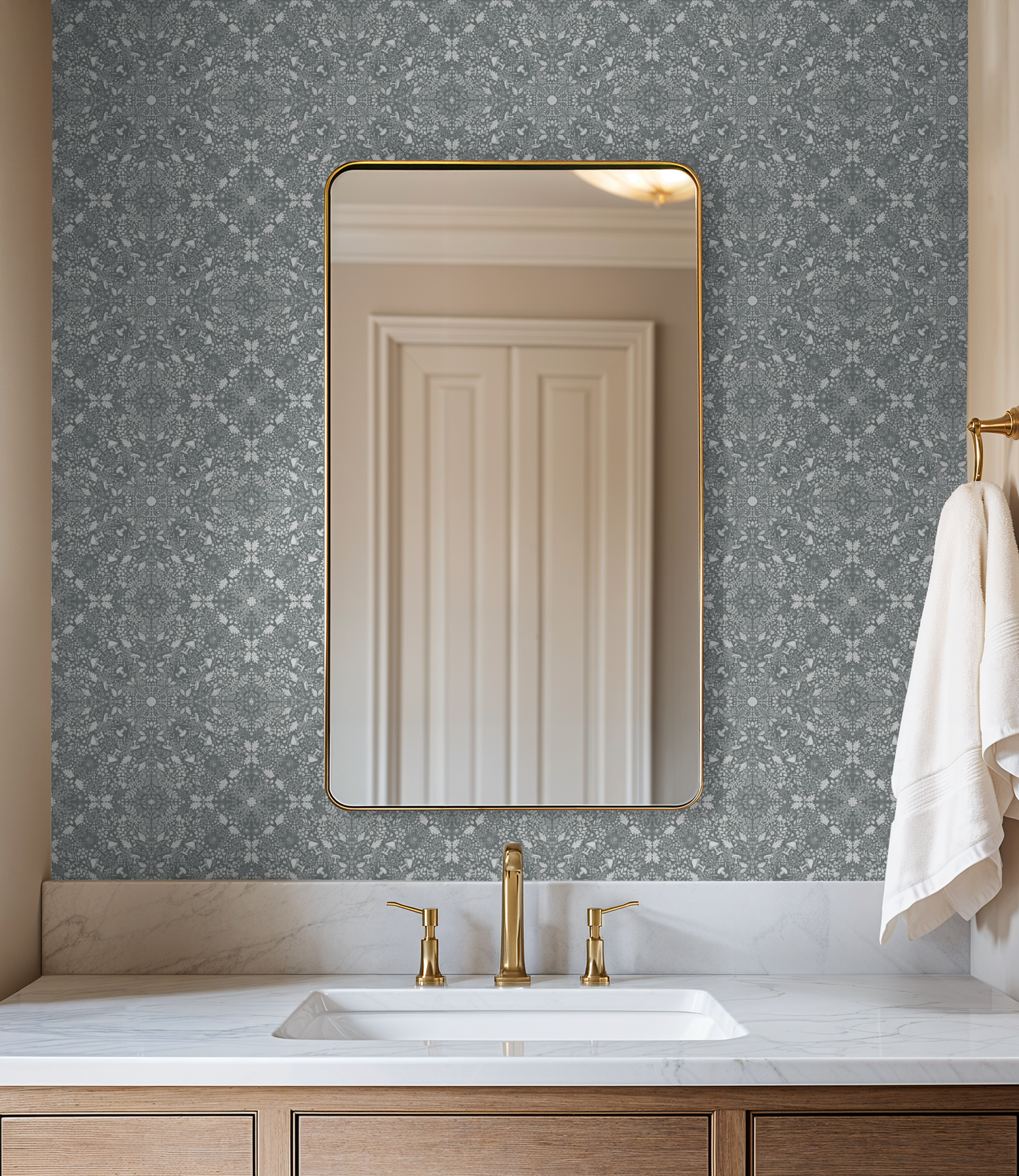 Bathroom vanity with brass fixtures and a rectangular mirror mounted on a navy Woodland Lace wallpaper accent wall.