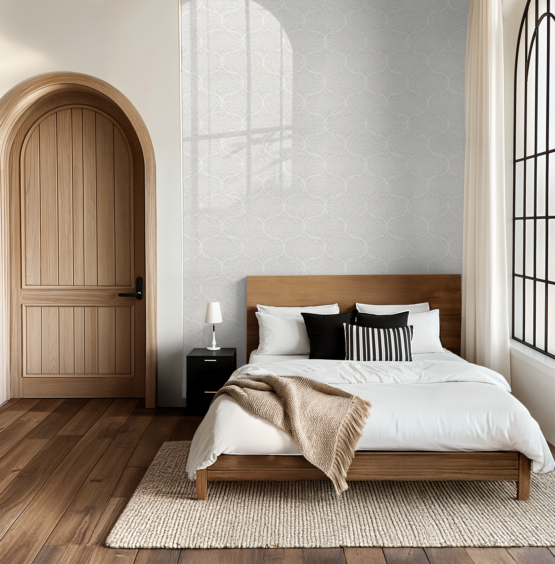Modern bedroom with wooden bed, nightstand, and arched door with a subtle grey dotted geometric wallpaper.