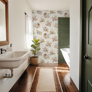 Bathroom with floral wallpaper, sink, and plant