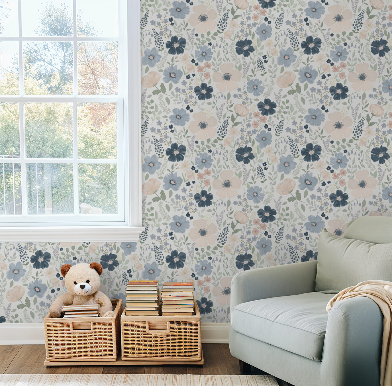 Anemone floral wallpaper shown beside a large window in a cozy reading corner with a sage armchair and woven book baskets.