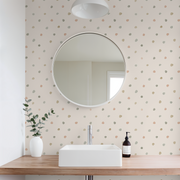 Bathroom with round mirror, sink, and polka dot wallpaper