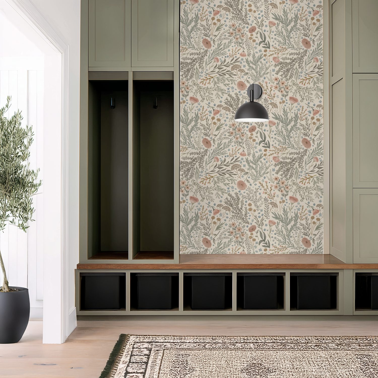Sage green mudroom lockers beside a feature wall of Bronte Woodland Fauna Floral wallpaper full of layered greens and gentle rust-pink florals.