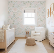 Nursery room with floral wallpaper, crib, chair, and ottoman.