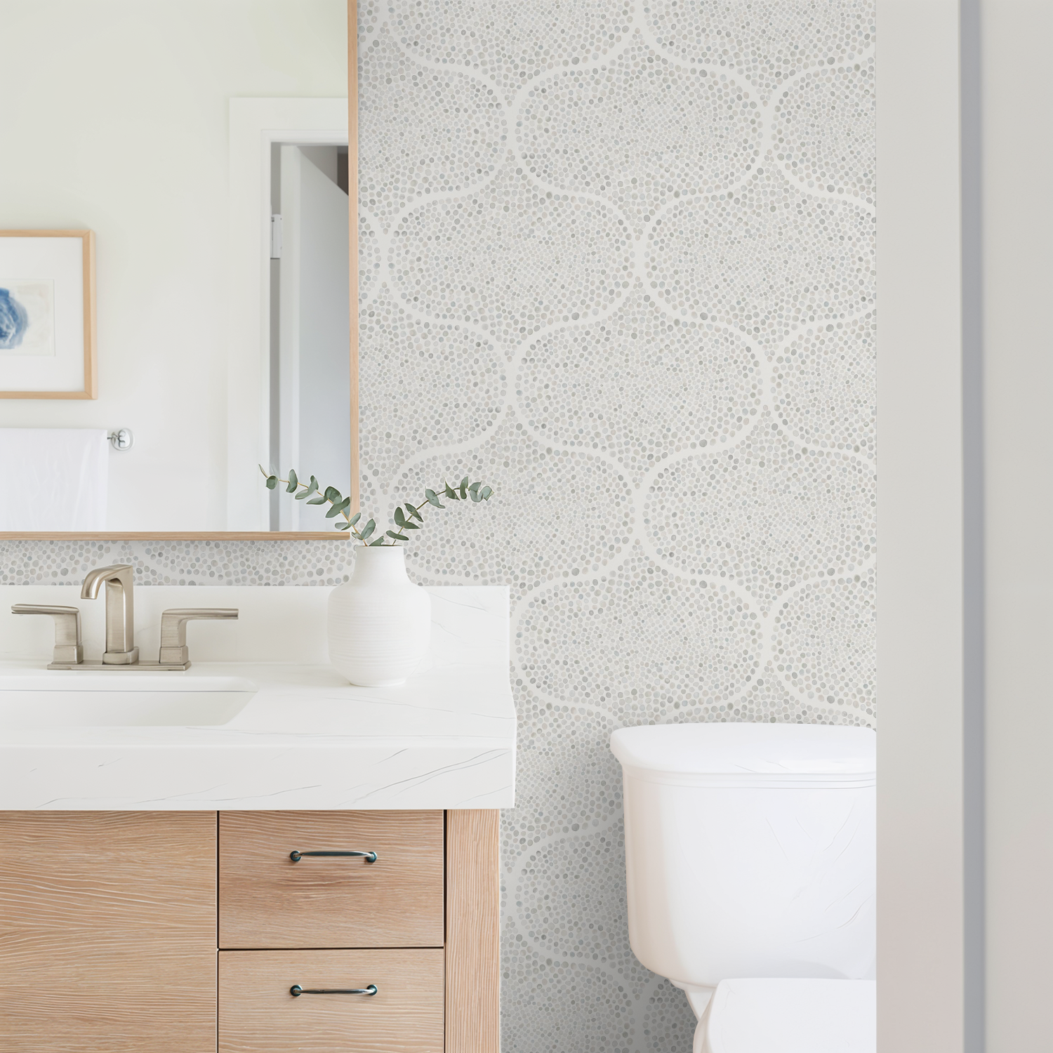 Bathroom with a grey geometric patterned wall, wooden vanity, and white toilet.