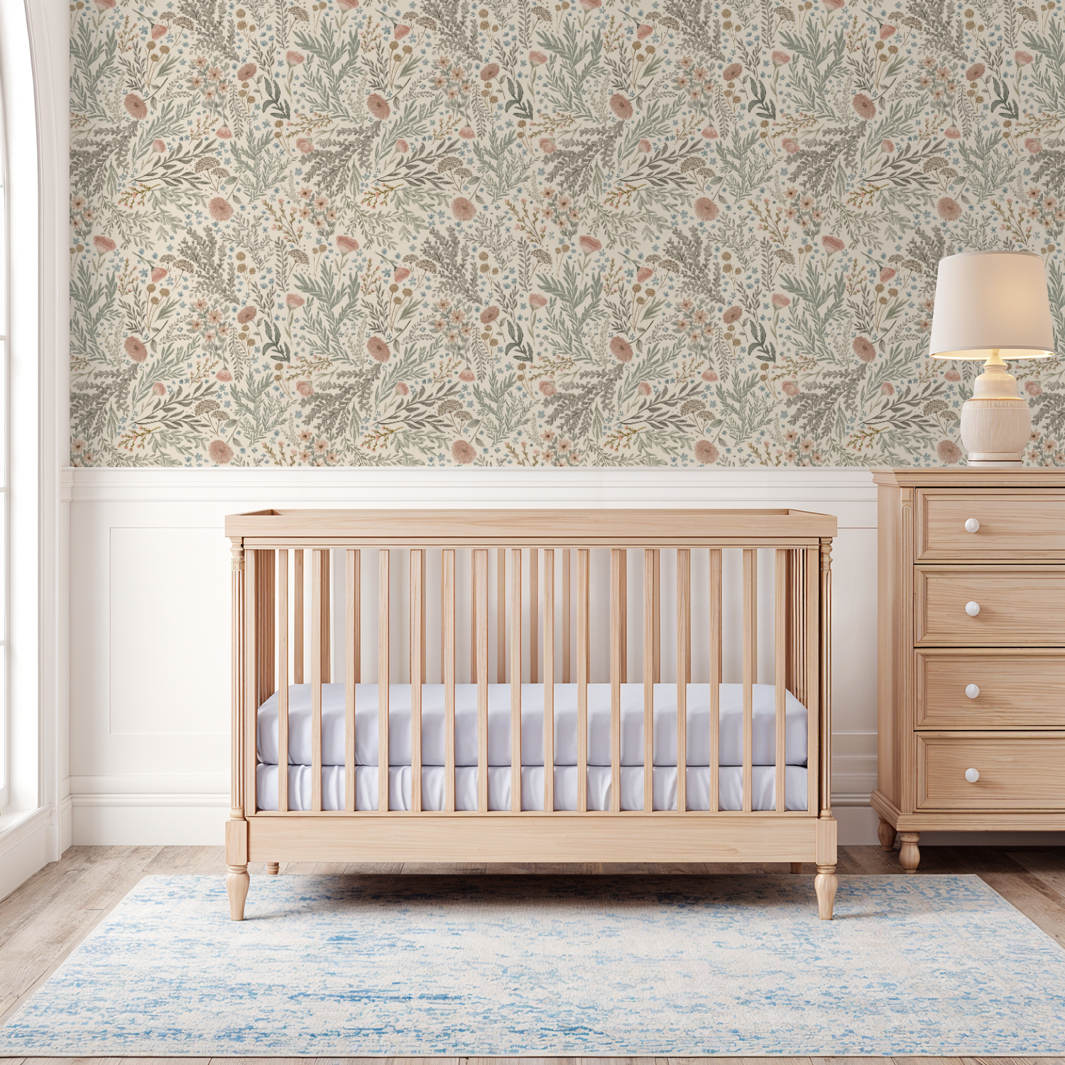 Nursery room with a wooden crib and dresser against a floral wallpapered wall.