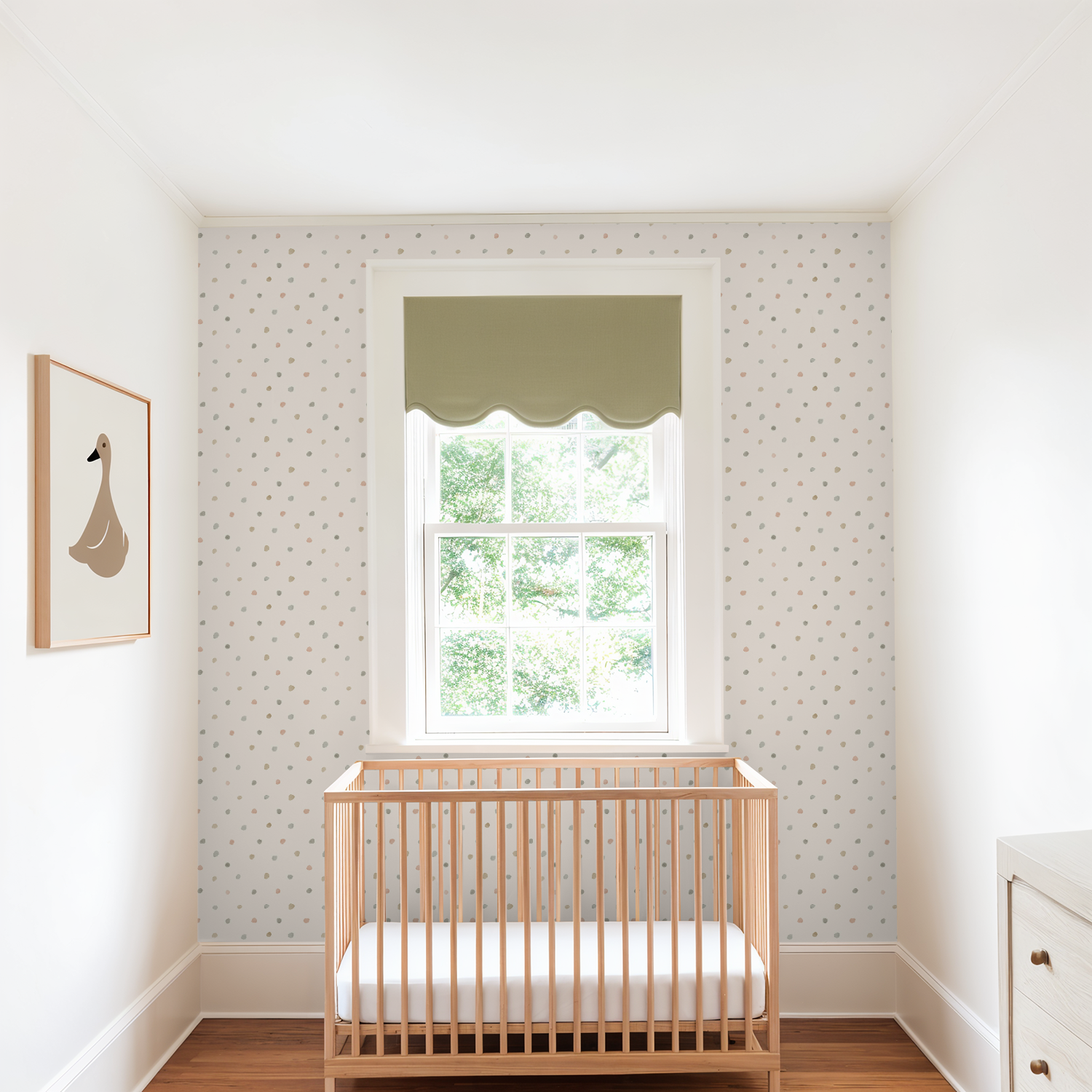 Bright nursery with wood crib and green scalloped window shade, styled with Bronte Watercolor Polka Dots wallpaper in soft cream with multicolored watercolor dots.