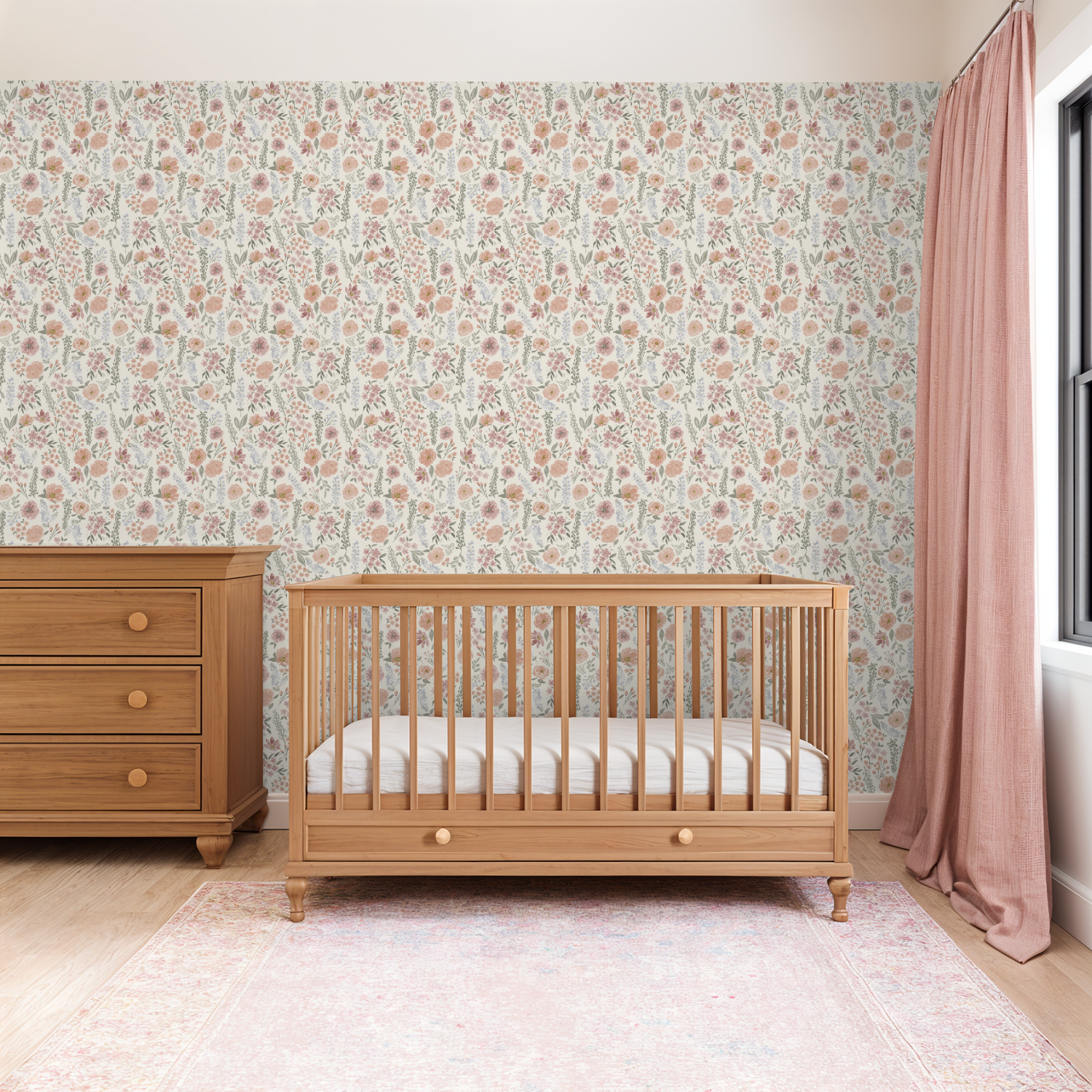 Warm nursery with natural wood furniture and pink curtains, highlighted by Consider the Wildflowers wallpaper’s hand-painted floral pattern.