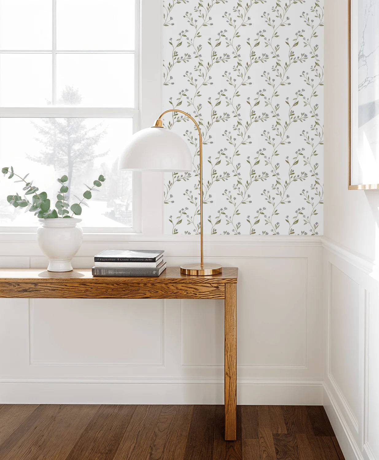 Modern interior with a wooden console table, white lamp, and Tanglewood Trailing wallpaper.