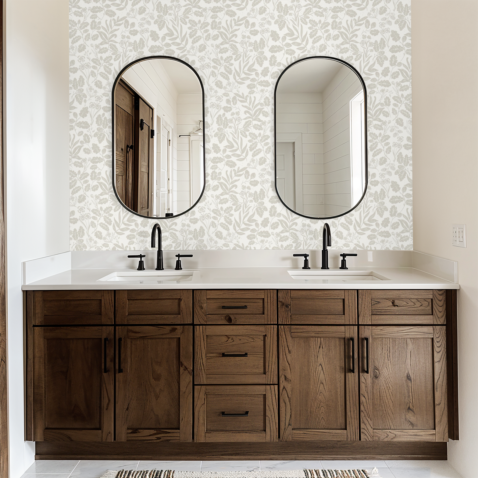 Bathroom vanity with wooden cabinets, white countertop, and two oval mirrors on patterned wallpaper.