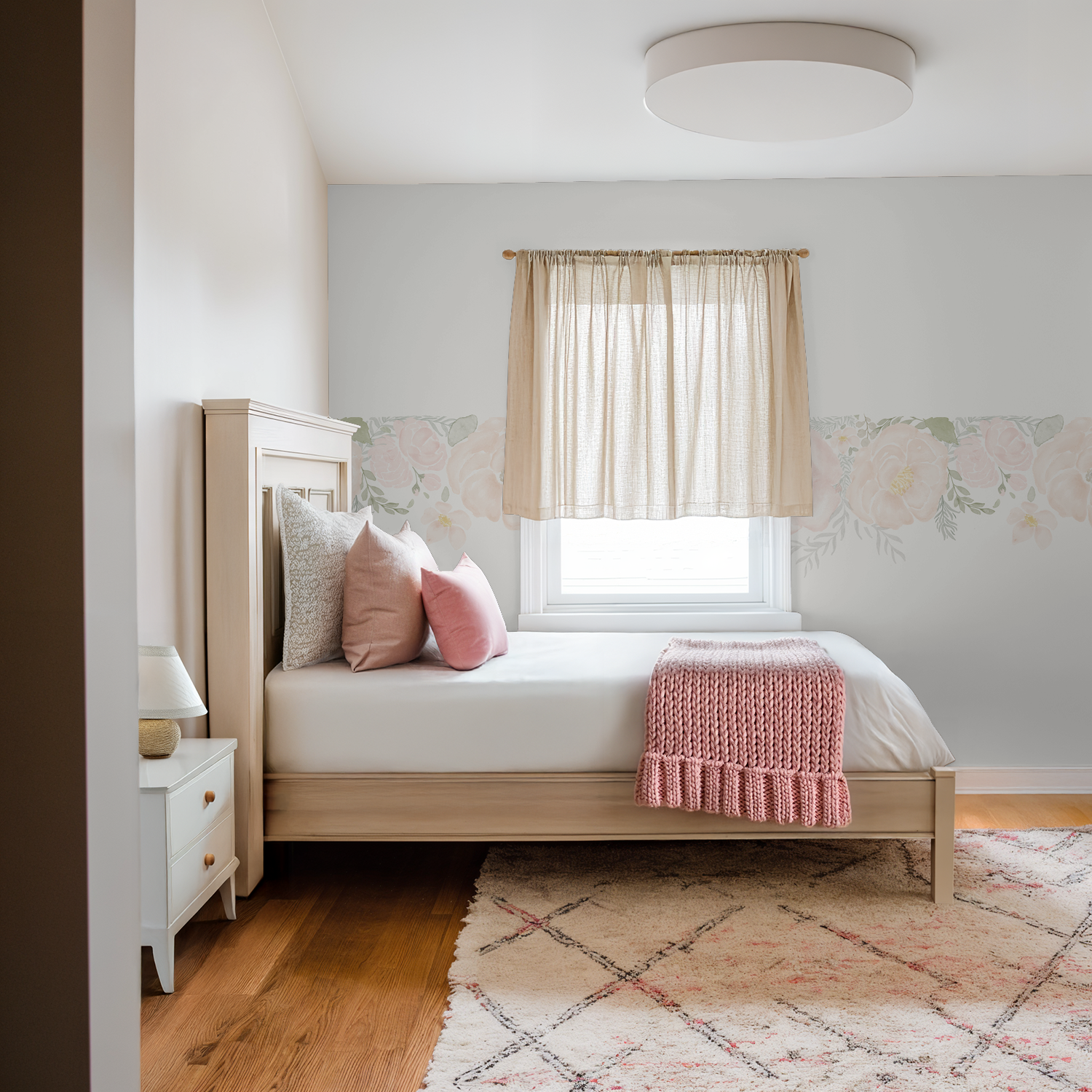 Bedroom with soft blush floral peony wallpaper border, beige curtains, and pink accents.