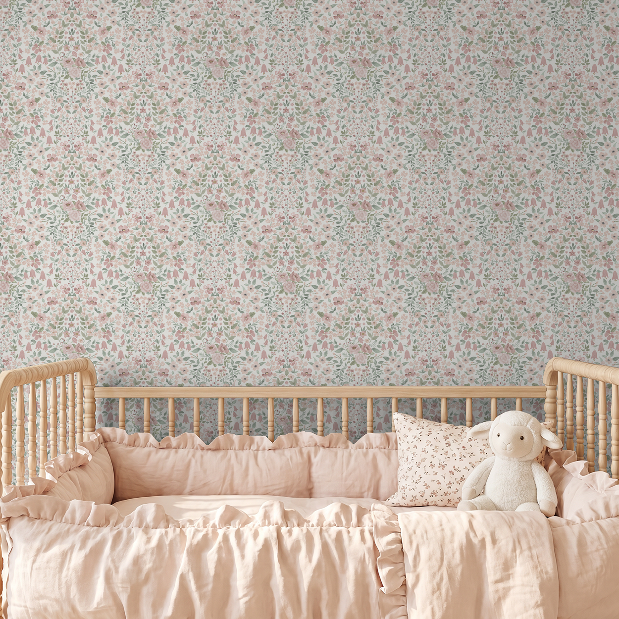 Baby girl nursery with blush wildflower wallpaper, wooden crib, and soft pink bedding.