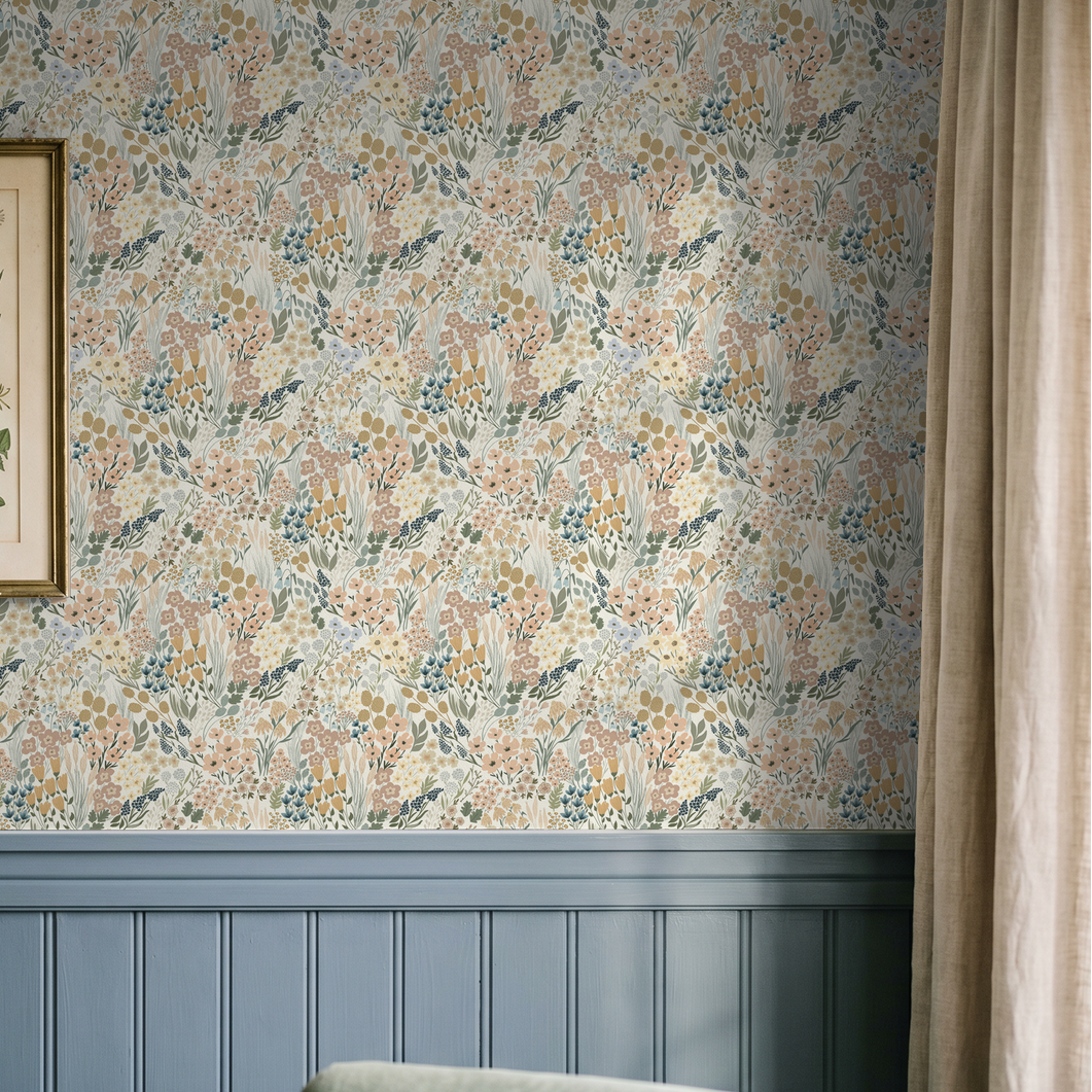 Botanical meadow wallpaper above blue wainscoting in cottage-inspired room