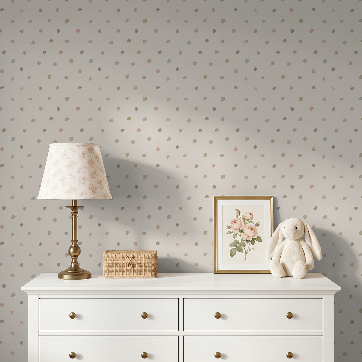 Bronte Dots pastel polka dot wallpaper in cozy nursery with dresser, lamp, and decor.