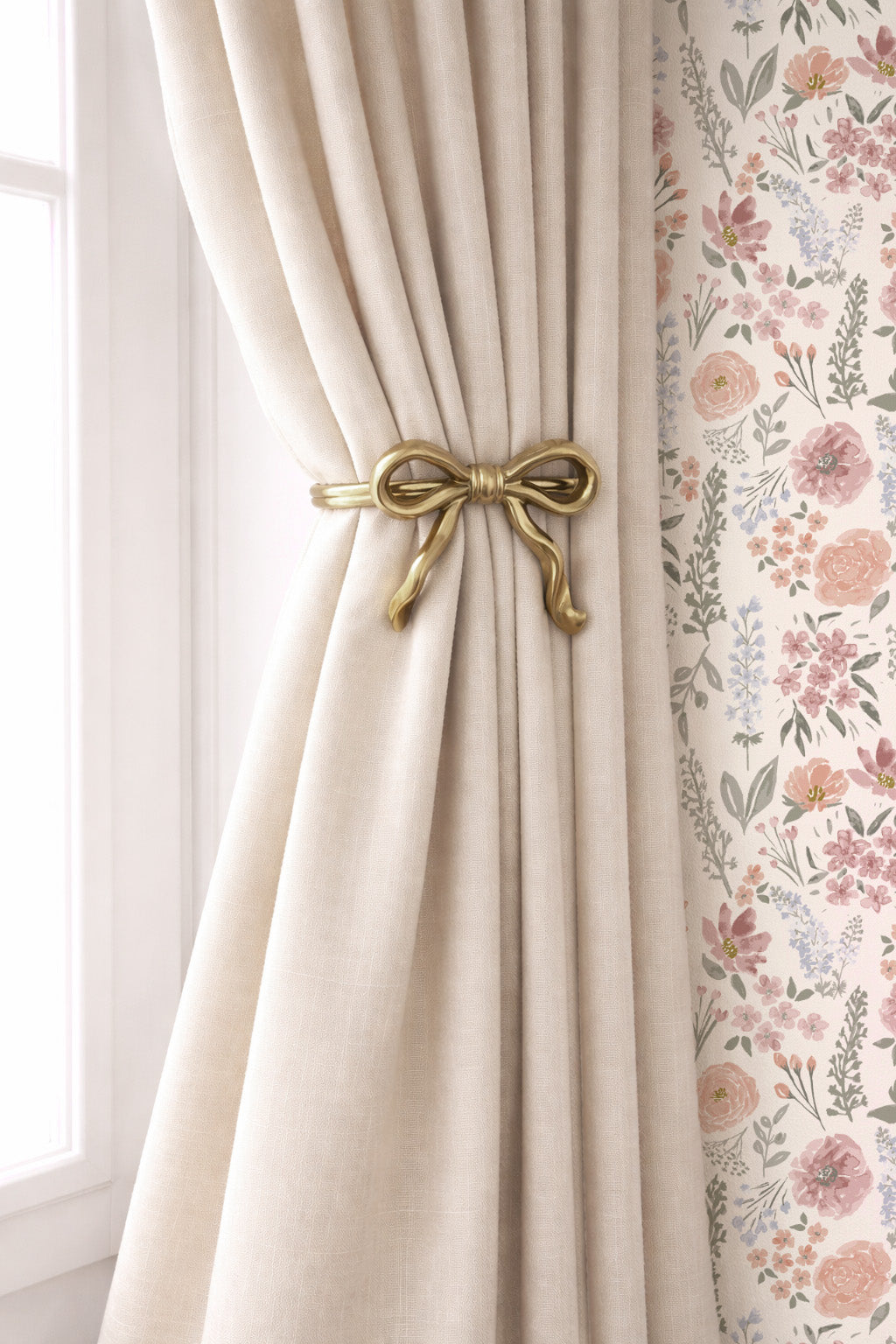 A close-up of a cream-colored curtain tied back with a decorative gold bow tie, next to a floral-patterned curtain panel.