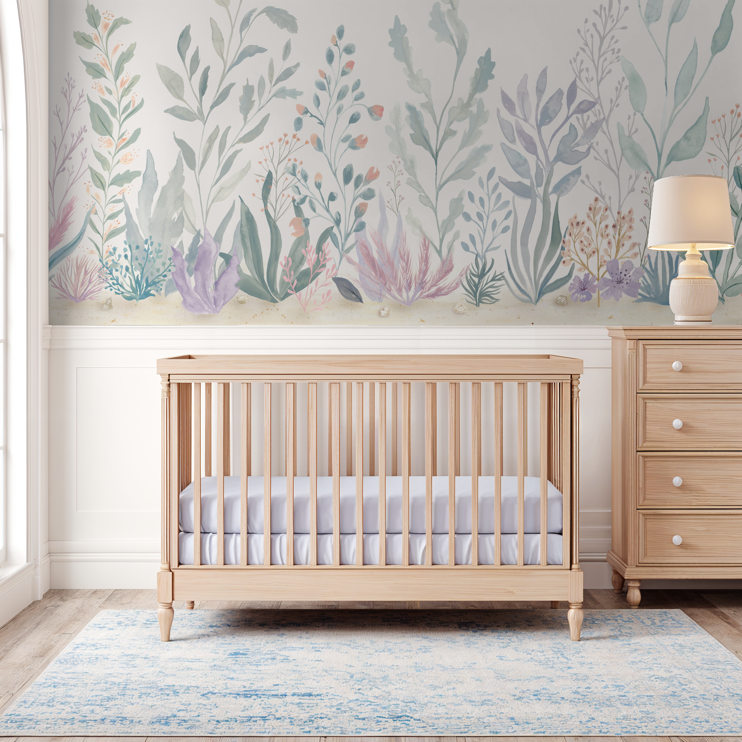 Floral Reef mural with soft green, blue, lavender, and coral sea plants above white nursery panelling.