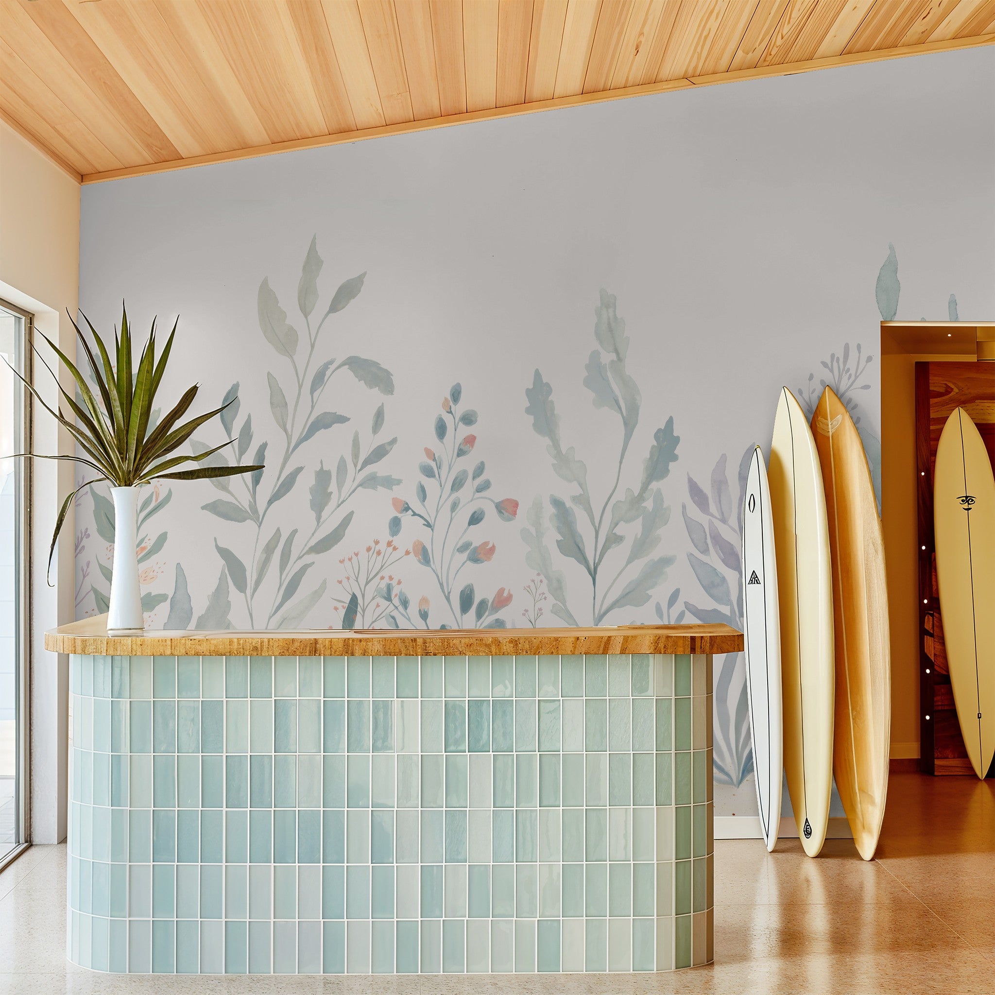 Pastel underwater botanical mural with seaweed, coral, and floral reef details in a coastal room with surfboards.