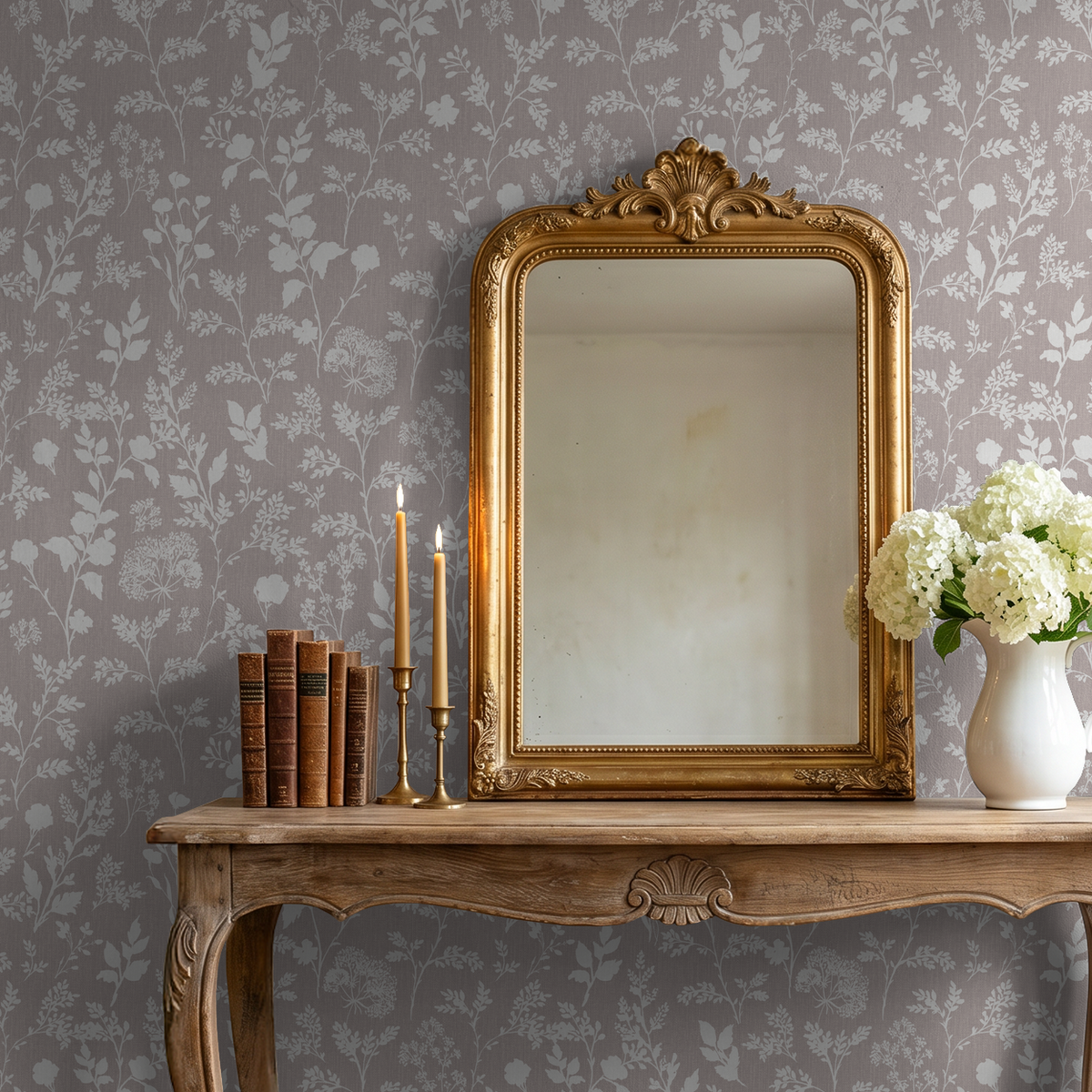 Mauve floral wallpaper with white botanical silhouettes behind vintage mirror and table.