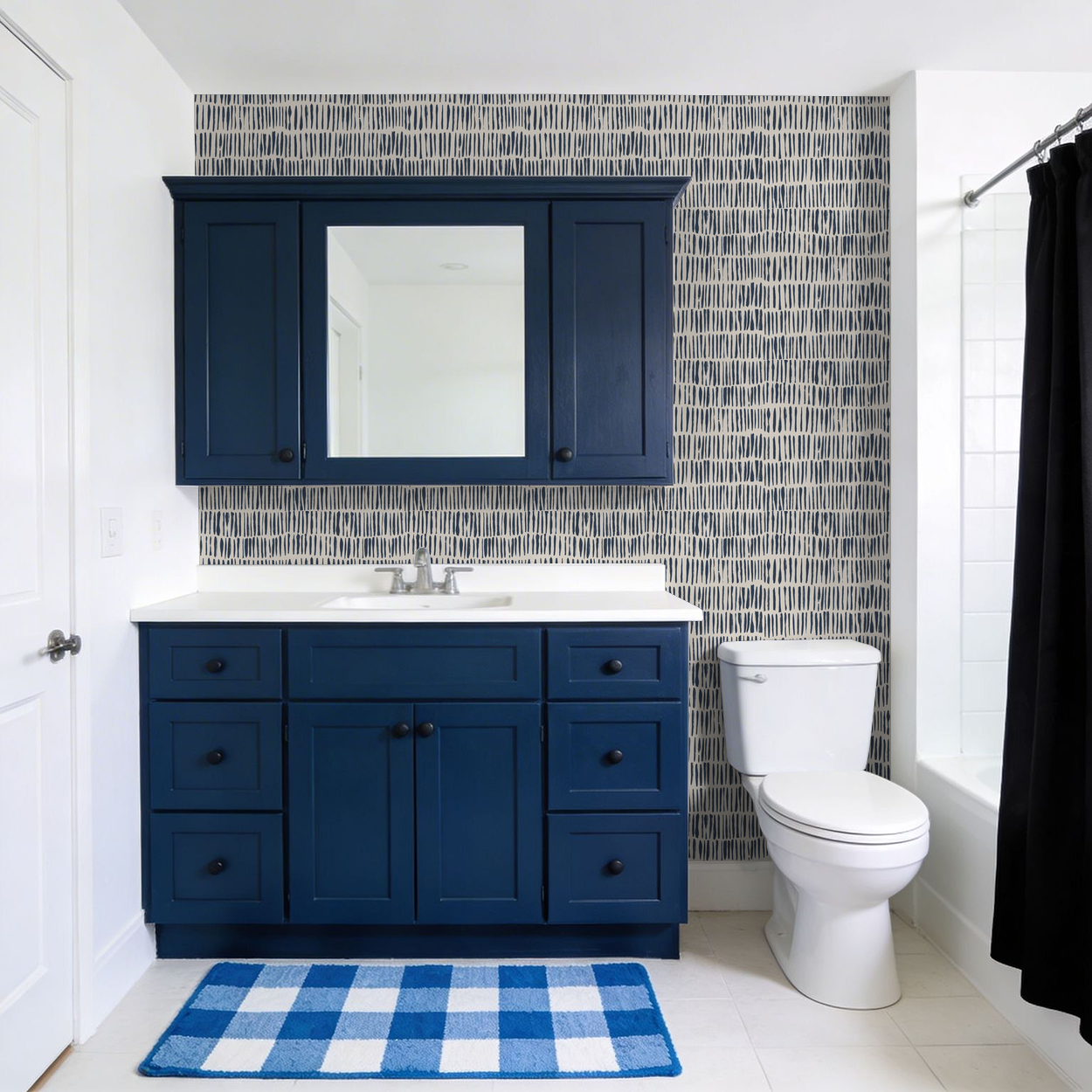 Navy brushstroke wallpaper in modern bathroom with navy cabinet and white fixtures.