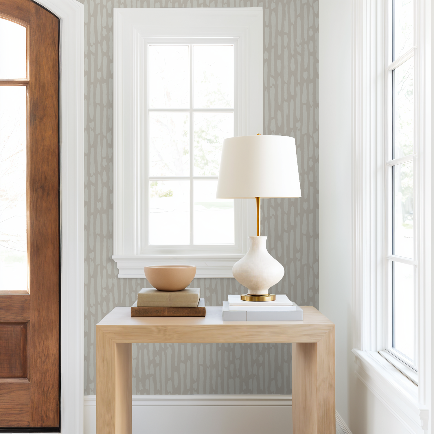 Neutral textured wallpaper in modern entryway with wood console table and soft lighting