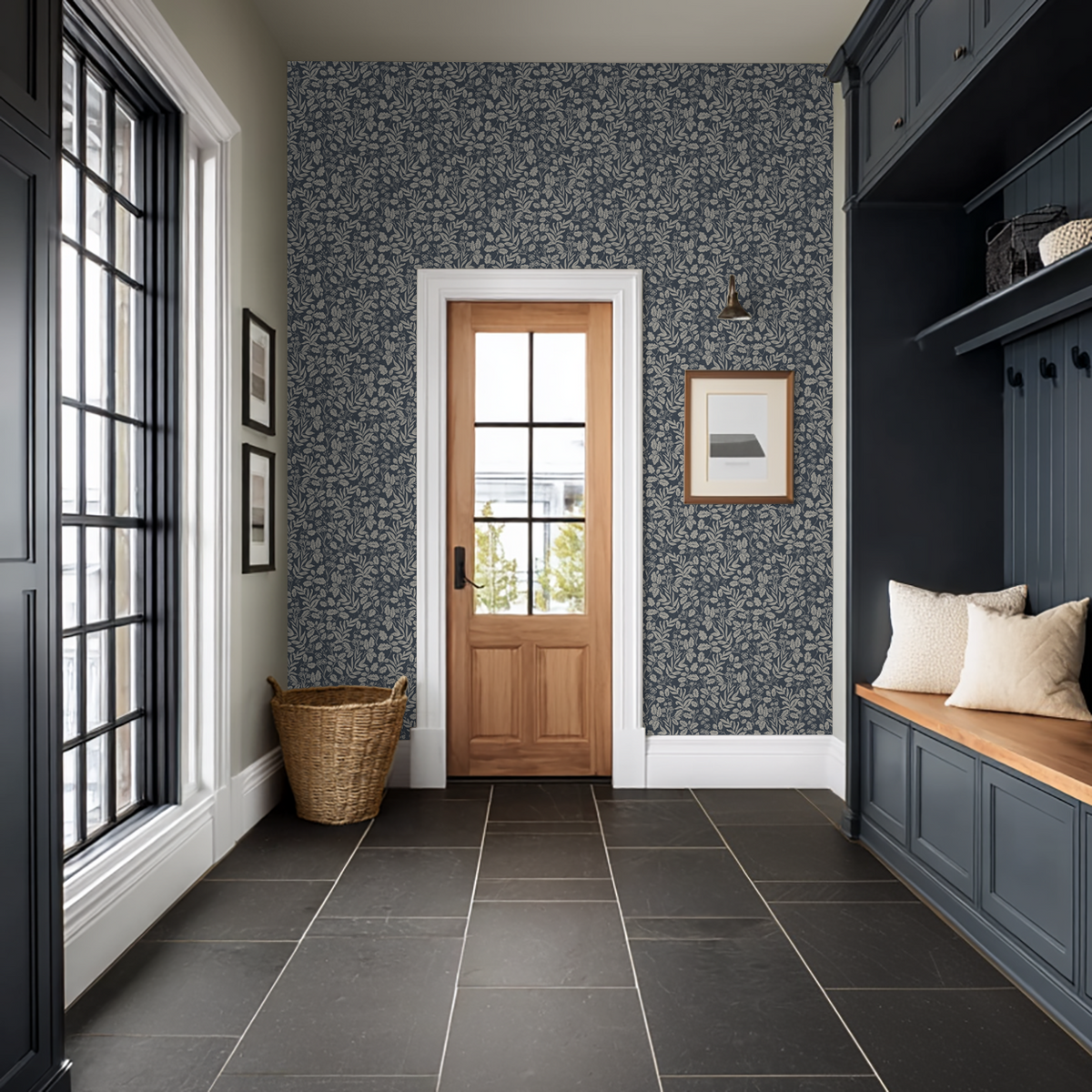 Oak and Acorn Navy botanical wallpaper in an entryway with dark blue built-ins and wood door.
