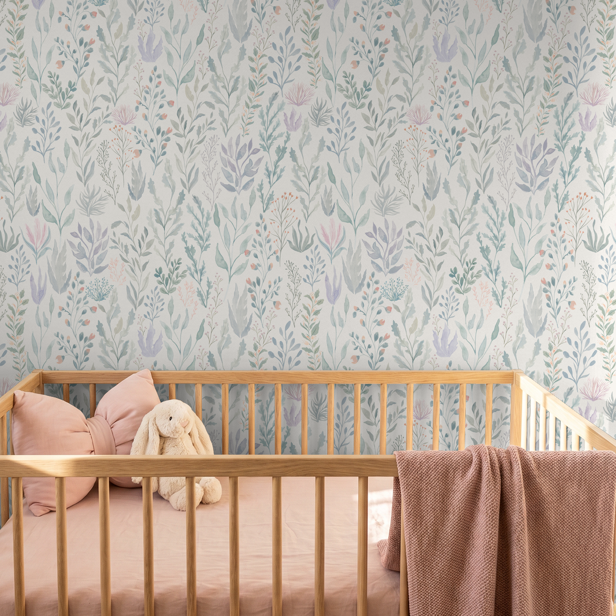 Pastel floral wallpaper with seafoam and lavender hues in a nursery with a wooden crib.