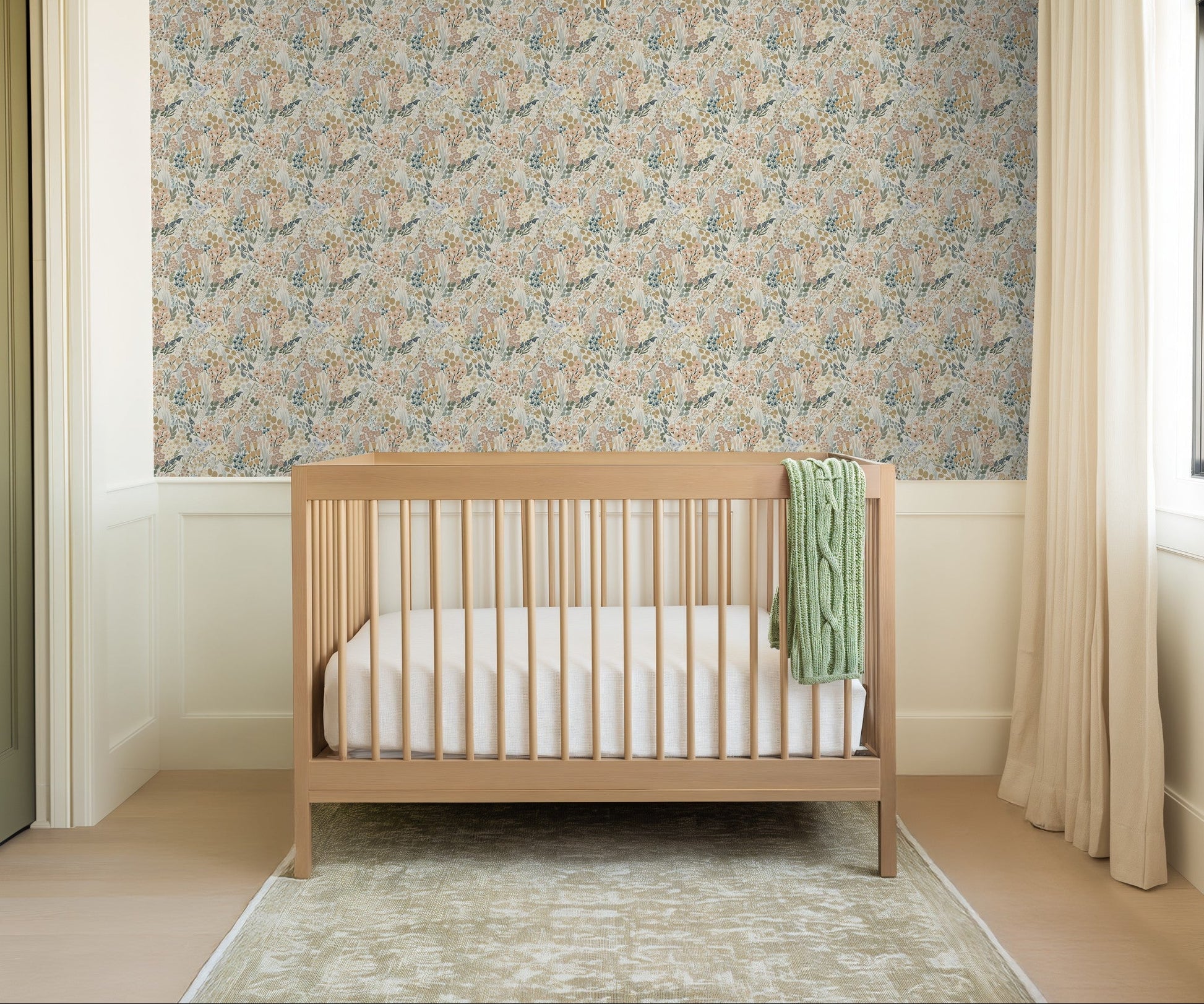 Pastel wildflower wallpaper in airy nursery with wood crib and neutral decor