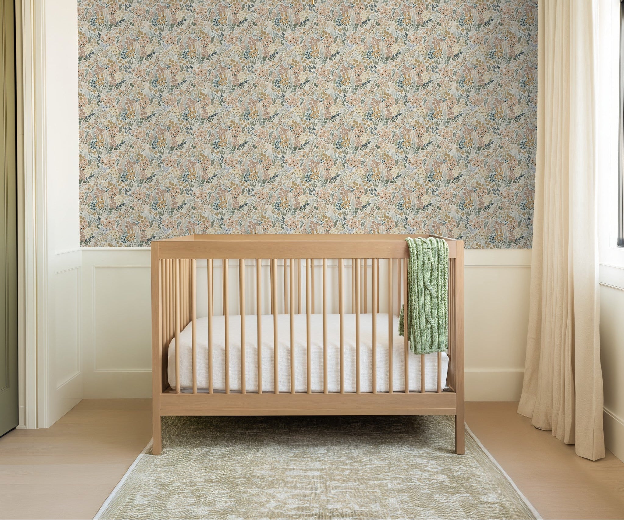Pastel wildflower wallpaper in airy nursery with wood crib and neutral decor