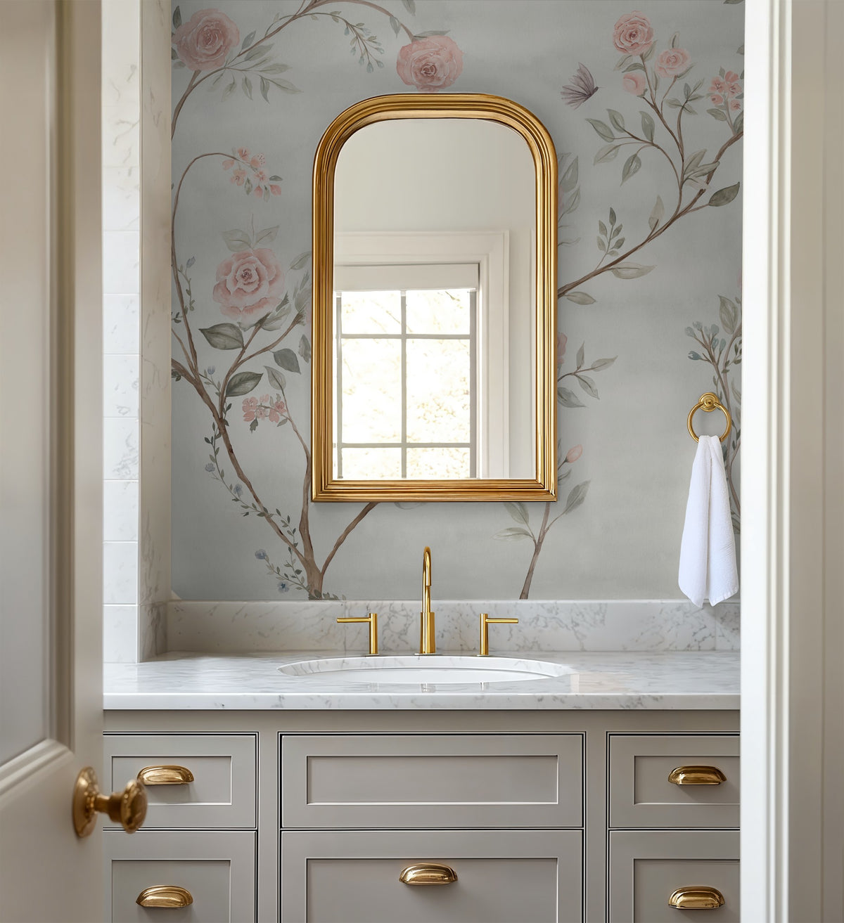 Romantic botanical wallpaper with blush pink roses and climbing branches in an elegant powder room.