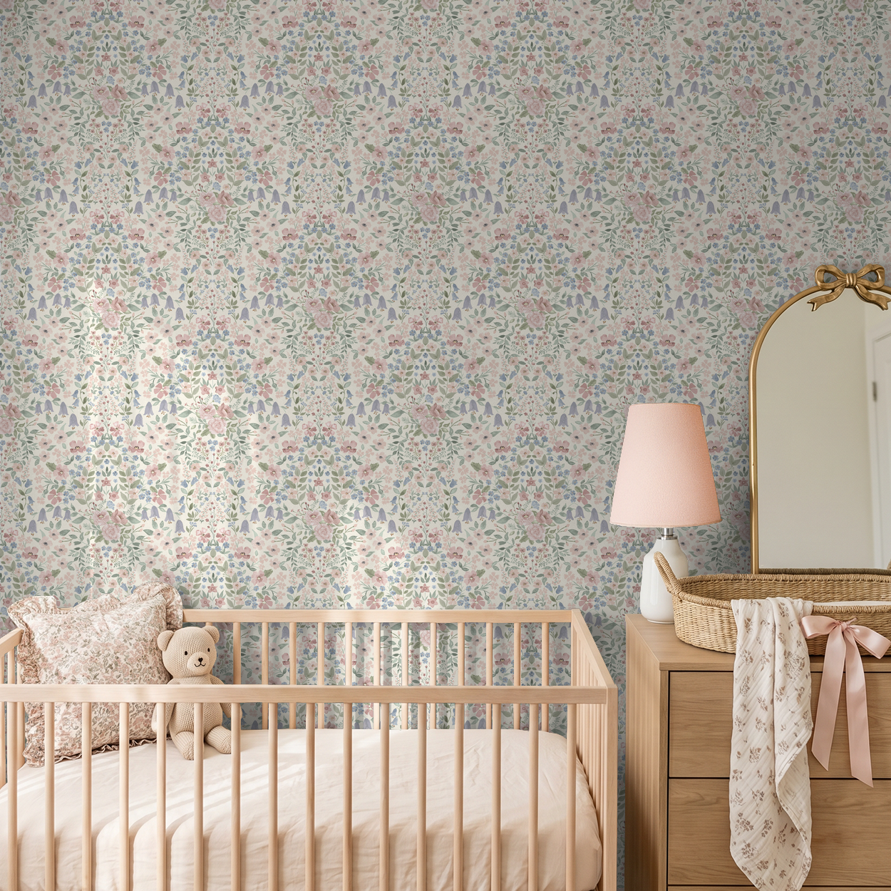 Romantic wildflower damask wallpaper in a soft vintage nursery with blush decor and natural wood crib.