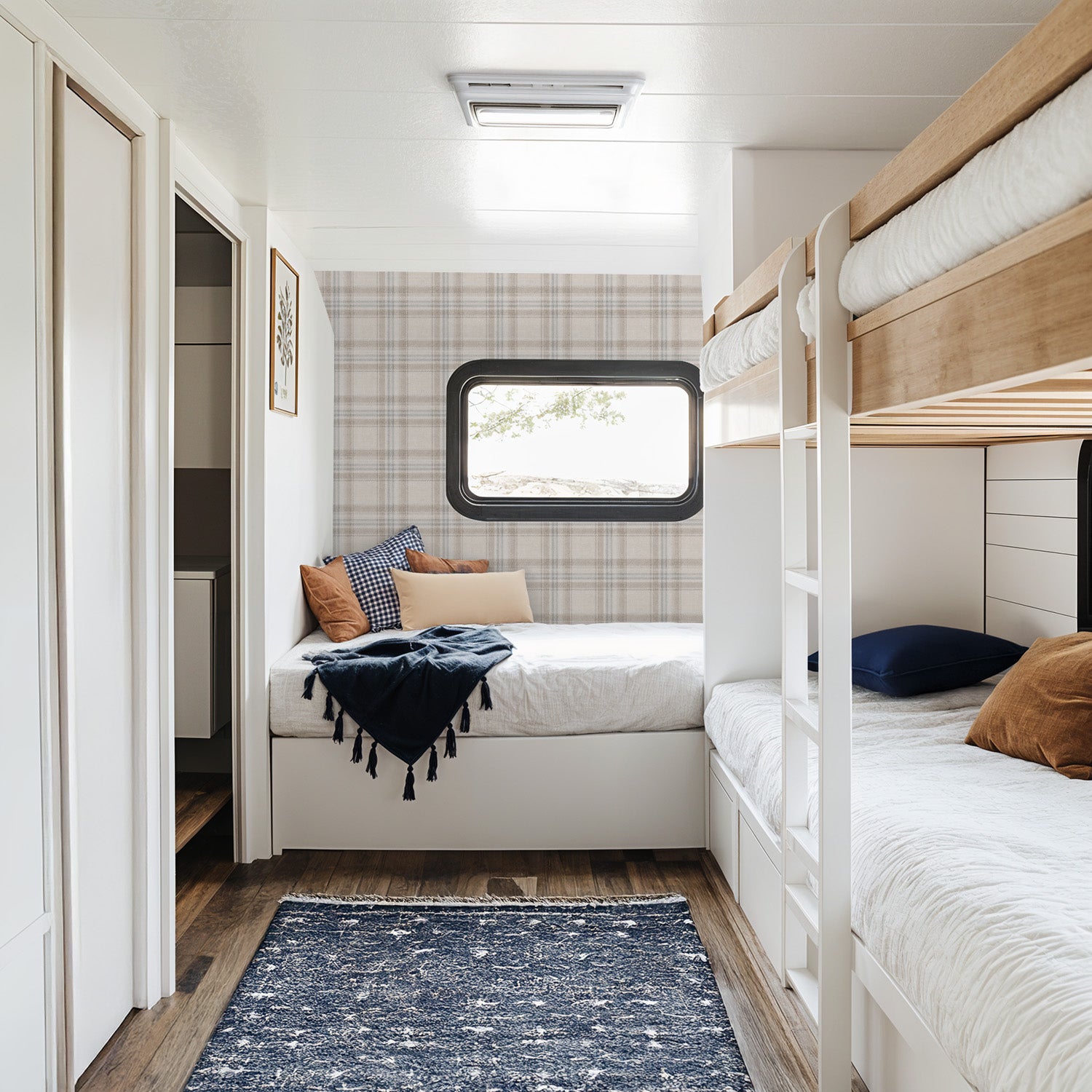 Small bedroom with bunk beds and a window, featuring Tweed Plaid  – Blue and Taupe wallpaper and wooden flooring.