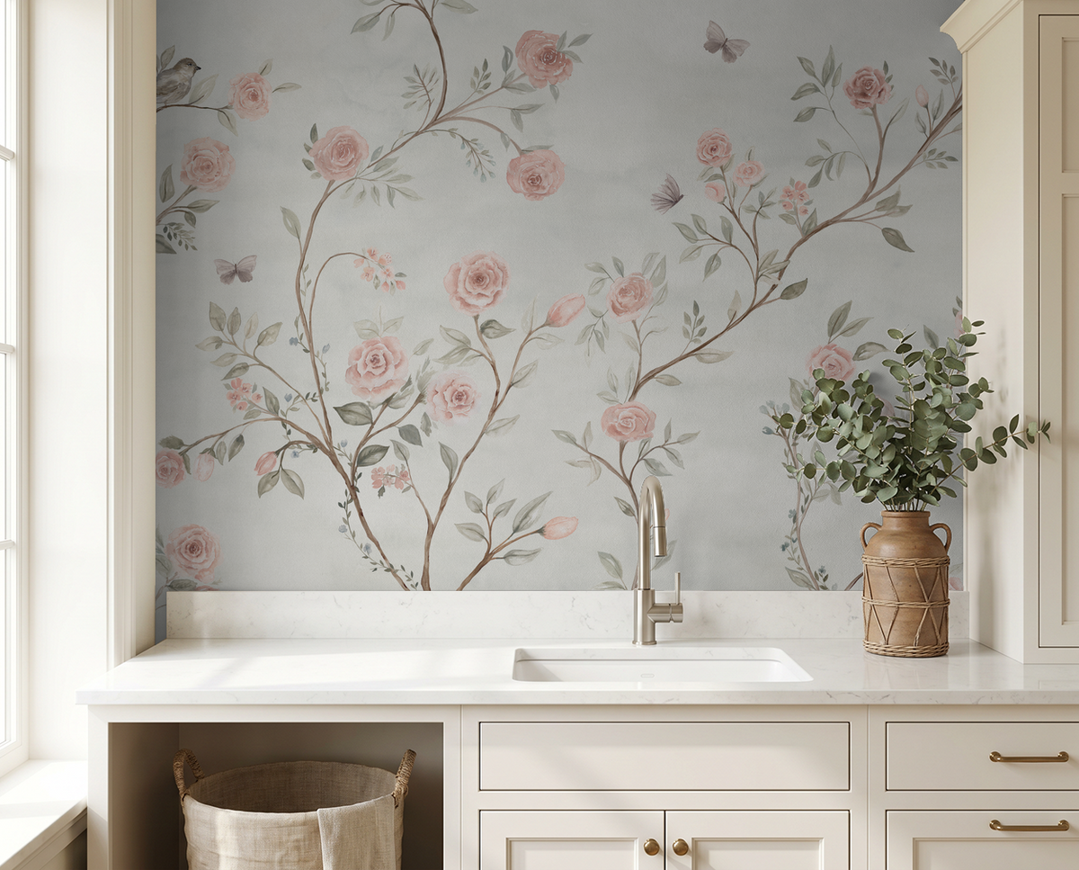 Watercolor botanical wallpaper with blush roses and climbing branches in a cottage laundry room.