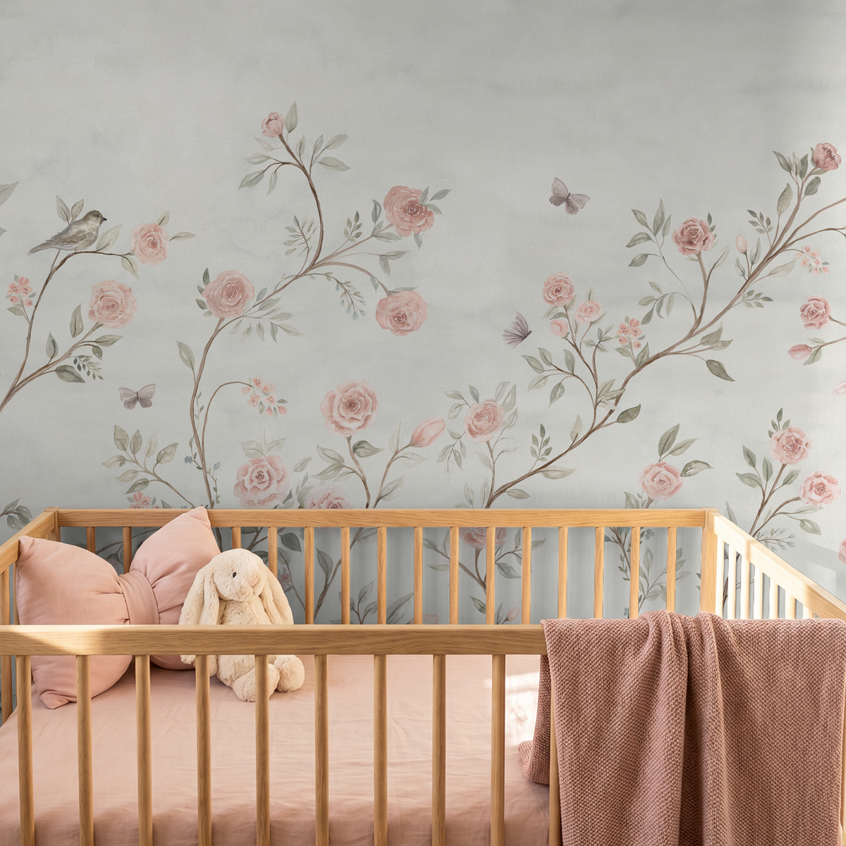 Whimsical rose wallpaper with birds, butterflies and watercolor botanicals in a soft pink nursery.